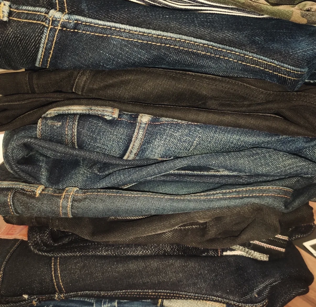 Close-up of a stack of raw and washed selvedge denim